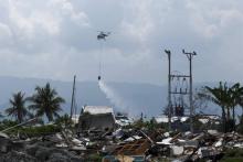 Des hélicoptères aspergent de liquide désinfectant plusieurs zones de Palu ravagée par un séisme suivi d'un tsunami, le 18 octobre 2018 en Indonésie