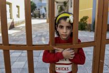 Une fillette syrienne, Jasmine Dabash, le 14 setpembre 2018 derrière le portail d'une école près du centre d'accueil albanais où s'est installée depuis l'été sa famille, dans la banlieue de Tirana