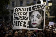 Des manifestants portent une banderole "Femmes battues Justice complice Assez!" lors d'un rassemblement organisé par l'actrice Muriel Robin contre les violences faites aux femmes, le 6 octobre 2018 à 