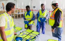 Un technicien échange avec des travailleurs immigrés sur le chantier du stade de Losail à Doha, le 30 août 2018