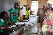 Un employé électoral explique le processus de vote à une électrice à Maputo, le 10 octobre 2018