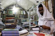 Un étudiant en théologie feuillette un livre dans une librairie de Najak en Irak, le 16 août 2018