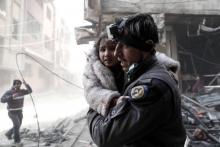 Un Casque blanc syrien évacue une petite fille près d'un site visé par un bombardement attribué au régime syrien, à Douma, alors bastion rebelle près de Damas, le 25 février 2017