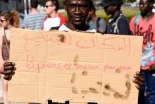 "Papiers et maisons pour tous" peut-on lire sur ce panneaubrandi lors d'une manifestation pour protester contre l'expulsion de réfugiés d'une école, à Nantes, le 2 août 2018