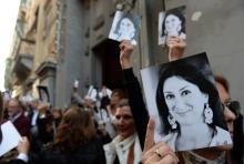 Des personnes brandissent des photos de la journaliste maltaise Daphne Caruana Galizia, à La Valette, le 16 avril 2018