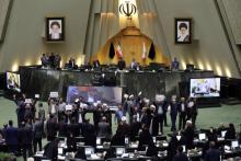 Des députés iraniens brandissent des pancartes exprimant leur désaccord avec le projet de loi contre le financement du "terrorisme", adopté par le Parlement, à Téhéran le 7 octobre 2018