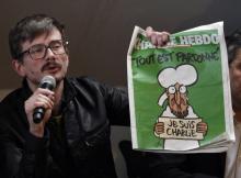 Le dessinateur Renald Luzier, aka Luz, à Paris, le 13 janvier 2015, montre le premier numéro de Charlie Hebdo sorti après les attentats visant le journal satyrique