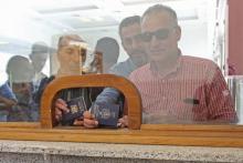 Des voyageurs montrent leur passeport afin de passer la frontière entre la Jordanie et la Syrie au poste-frontière de Jaber (appelé Nassib côté syrien), rouvert après trois ans de fermeture, le 15 oct