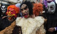 De jeunes marocains portant des masques d'horreur et des peaux animales célèbrent le festival de Boujloud dans la ville de Salé, le 27 octobre 2018