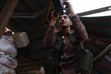 Un rebelle syrien membre du Front national de libération (FNL) pointe son arme en direction des forces gouvernementales syriennes, dans le sud-est de la province d'Idleb, le 9 octobre 2018