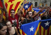 De jeunes Catalans brandissent le drapeau pro-indépendance lors d'une manifestation à Barcelone le 1er octobre 2018