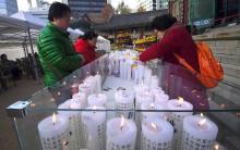 Des Sud-Coréennes installent des bougies pour le succès de leurs proches à l'examen annuel d'entrée à l'université, dans un temple bouddhiste de Séoul le 23 novembre 2017