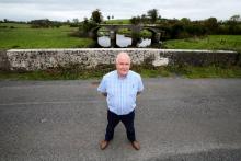 Un habitant de Drummully, John Connolly, sur le pont sur la rivière Finn au milieu duquel passe la frontière entre l'Irlande et l'Irlande du Nord près de la ville irlandaise de Clones, le 27 septembre