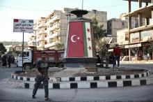 Un rebelle pro-turc en faction le 9 octobre 2018 au rond-point rebaptisé "Salah Aldin Alaiobi" dans la ville d'Afrine, en Syrie, où des habitants ont accusé les insurgés d'exactions