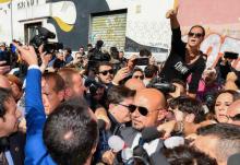 Une femme apostrophe le ministre italien de l'Intérieur Matteo Salvini (de dos) qui s'est rendu dans le quartier de San Lorenzo à Rome devant un squat où une adolescente a été retrouvée morte et qu'il
