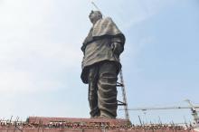 Des ouvriers indiens prennent la pose au pied de la "Statue de l'Unité" représentant Sardar Vallabhbhai Patel, figure historique célébrée par les nationalistes hindous, le 18 octobre 2018