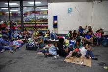 Des migrants du Honduras en route pour les Etats-Unis se reposent dans une station service de Zacapa, au Guatémala, le 16 octobre 2018
