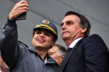 Photo archives montrant le candidat d'extrême droite à la présidentielle brésilienne, Jair Bolsonaro, posant pour un selfie avec une militaire le 17 août 2018 à Sao Paulo