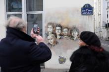 Portraits de 5 des victimes de l'attaque contre Charlie Hebdo, sur un mur de la rue où était situé l'hebdomadaire satirique à Paris, le 7 janvier 2018