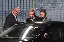 Des passants regardent le 22 novembre 2018 à Tokyo la photo de Carlos Ghosn, patron de Renault-Nissan, arrêté pour soupçons de malversations financières et fraude fiscale