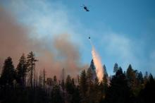 Image d'illustration d'un hélicoptère déversant de l'eau pour lutter contre l'incendie "Camp fire", à l'est de la ville de Paradise, en Californie, le 11 novembre 2018.