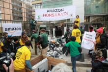 Des personnes déversent des déchets électroniques devant le siège d'Amazon France le 23 novembre 2018 à Clichy