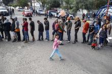 Des migrants d'Amérique centrale essayant de pénéterr aux Etats-Unis font la queue pour une distribution de nourriture à Tijuana au mexique le 15 novembre 2018