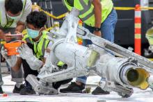 Au nord de Jakarta, le 5 novembre 2018, des enquêteurs de Lion Air examinent une partie du train d'atterrissage du Boeing qui s'est abîmé le 29 octobre au large de l'Indonésie