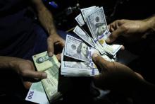 Un homme échange des rials iraniens contre des dollars américains à Téhéran, le 8 août 2018