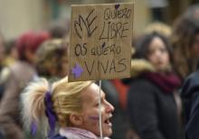 Une femme porte une pancarte avec les mots "Je veux être libre, je veux que vous soyez vivantes", lors d'une manifestation contre les violences conjugales le 25 novembre 2018 à Pampelune