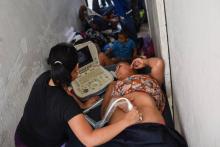 Une femme enceinte subit une échographie lors d'un arrêt de la caravane des migrants à Huixtla au Mexique, le 23 octobre 2018