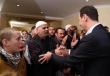 Le président syrien Bachar al-Assad entouré d'anciens otages druzes qui avaient été enlevés par le groupe Etat islamique (EI), à Damas, le 13 novembre 2018. Photo fournie par l'agence officielle syrie