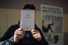 Un détenu du centre de détention de Salon-de-Provence pose avec le livre qu'il a choisi, "Frere d'âme" de David Diop, le 13 novembre 2018