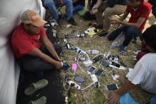 Des migrants, majoritairement honduriens, en route pour les Etats-Unis, rechargent leur téléphone portable dans un camp organisé dans un stade de Mexico, le 7 novembre 2018
