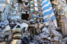 Des secouristes s'activent dans les décombres d'un immeuble de Magnitogorsk, dans l'Oural russe, partiellement détruit par une explosion due au gaz le 31 décembre 2018