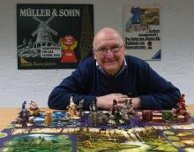 Tom Werneck, collectionneur de 79 ans, pose derrière un jeu de plateau au Bayerisches Spielearchiv, archives des jeux de société, à Munich, dans le sud de l'Allemagne, le 12 décembre 2018