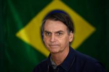 Le président élu d'extrême droite au Brésil, Jair Bolsonaro, alors candidat, passe devant un drapeau de son pays à Rio de Janeiro le 7 octobre 2018