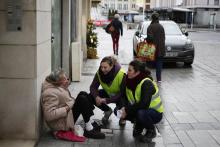 Ludivine Hilairet (C), employée dans un fast-food de 21 ans et Chloé Tessier, monitrice d'équitation en recherche d'emploi échangent avec un homme à Caen le 21 décembre 2018
