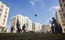 Des enfants palestiniens jouent au football au milieu de nouvelles unités de logement construites avec l'aide du Qatar à Khan Younès dans le sud de la bande de Gaza, le 20 novembre 2018