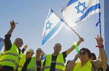Des manifestants israéliens portant des gilets jaunes et imitant la contestation en France protestent à Tel-Aviv contre l'augmentation du coût de la vie annoncée en 2019, le 14 décembre 2018