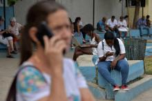 Des Cubains utilisent un point wifi public dans un parc de La Havane, le 5 décembre 2018