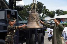 Des militaires philippins débarquent l'une des trois cloches de l'église de Balangiga restituées par les Etats-Unis à leur arrivée près de Manille, le 11 décembre 2018