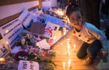 Une jeune Marocaine dépose une gerbe de fleurs lors d'un rassemblement devant l'ambassade danoise à Rabat le 22 décembre 2018 en hommage aux deux touristes scandinaves tuées au Maroc