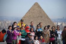 Des touristes posent devant les pyramides égyptiennes de Guizeh, près du Caire, le 28 décembre 2018, au lendemain d'un attentat ayant tué quatre personnes dont trois vacanciers