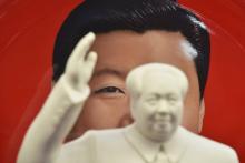 Une statue du leader communiste Mao Tsé-toung, devant une assiette décorative représentant le président chinois Xi Jinping, dans un magasin de souvenirs proche de la place Tiananmen, à Pékin, le 27 fé