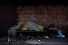 Un demandeur d'asile couché sur un banc, dans un camp à Saint-Denis, au nord de Paris, le 10 janvier 2019