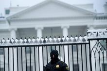 Un membre des services secrets américains devant la Maison Blanche enneigée le dimanche 13 janvier 2019 à Washington