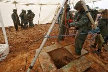 Photo prise lors d'une visite organisée par l'armée israélienne montrant un soldat utilisant une poulie au-dessus d'un trou creusé par l'armée pour localiser un tunnel que le Hezbollah libanais a creu