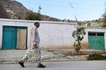 Un homme porte des bidons d'eau dans une rue de Kaboul, le 25 octobre 2018 en Afghanistan