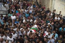Des hommes transportent le corps d'une mère de famille palestinienne, tuée selon les forces de sécurité palestiniennes par des jets de pierre de colons israéliens, lors de ses funérailles à Bidya, en 